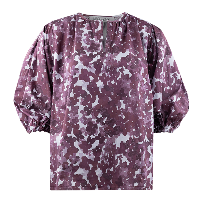 A womens quarter puff sleeve top. There is a floral pattern made up of different maroon shaded flowers. The background color of the top is white. There is a small slit down the neck of the top. 