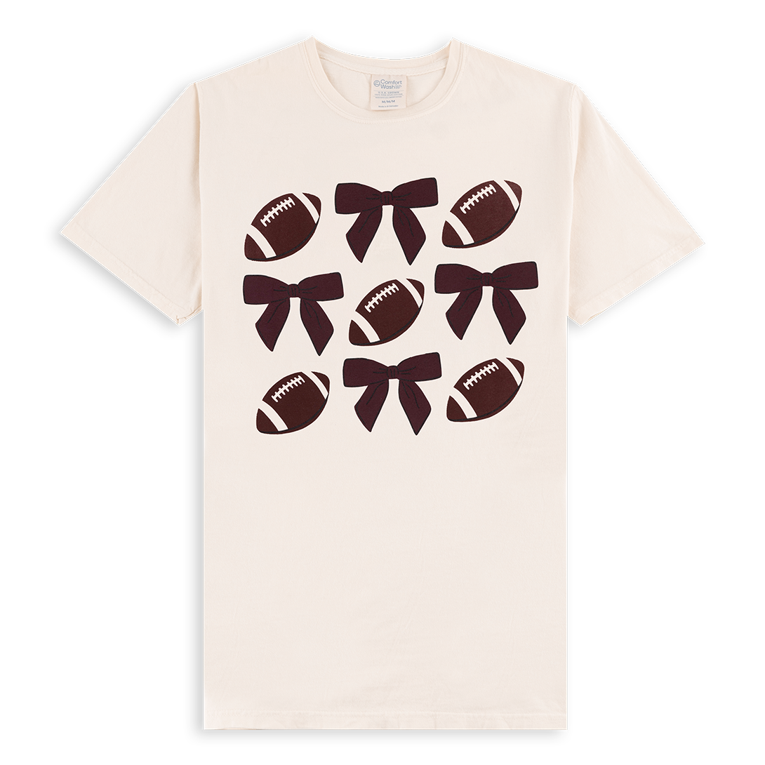 Cream t-shirt with footballs and maroon bows.