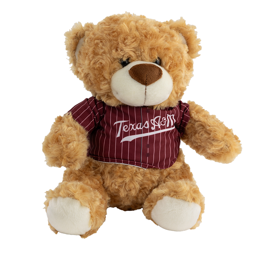 A light caramel brown bear that is wearing a maroon and white striped baseball jersey with 'Texas A&M' written across the chest