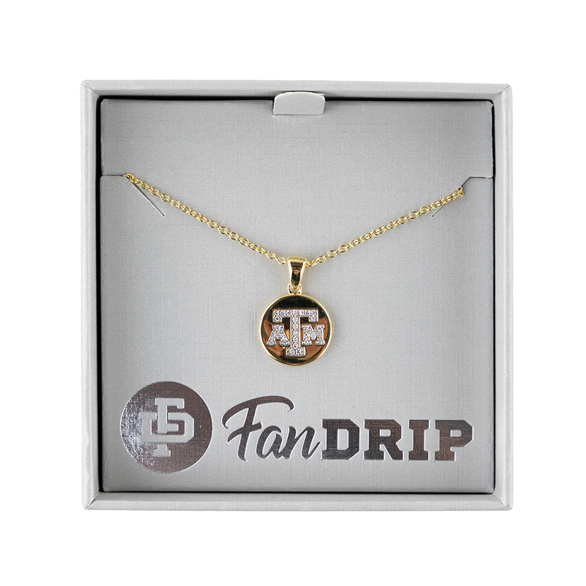 A gold necklace with a gold circular pendant. The pendant has A&M printed in diamond block letters. 