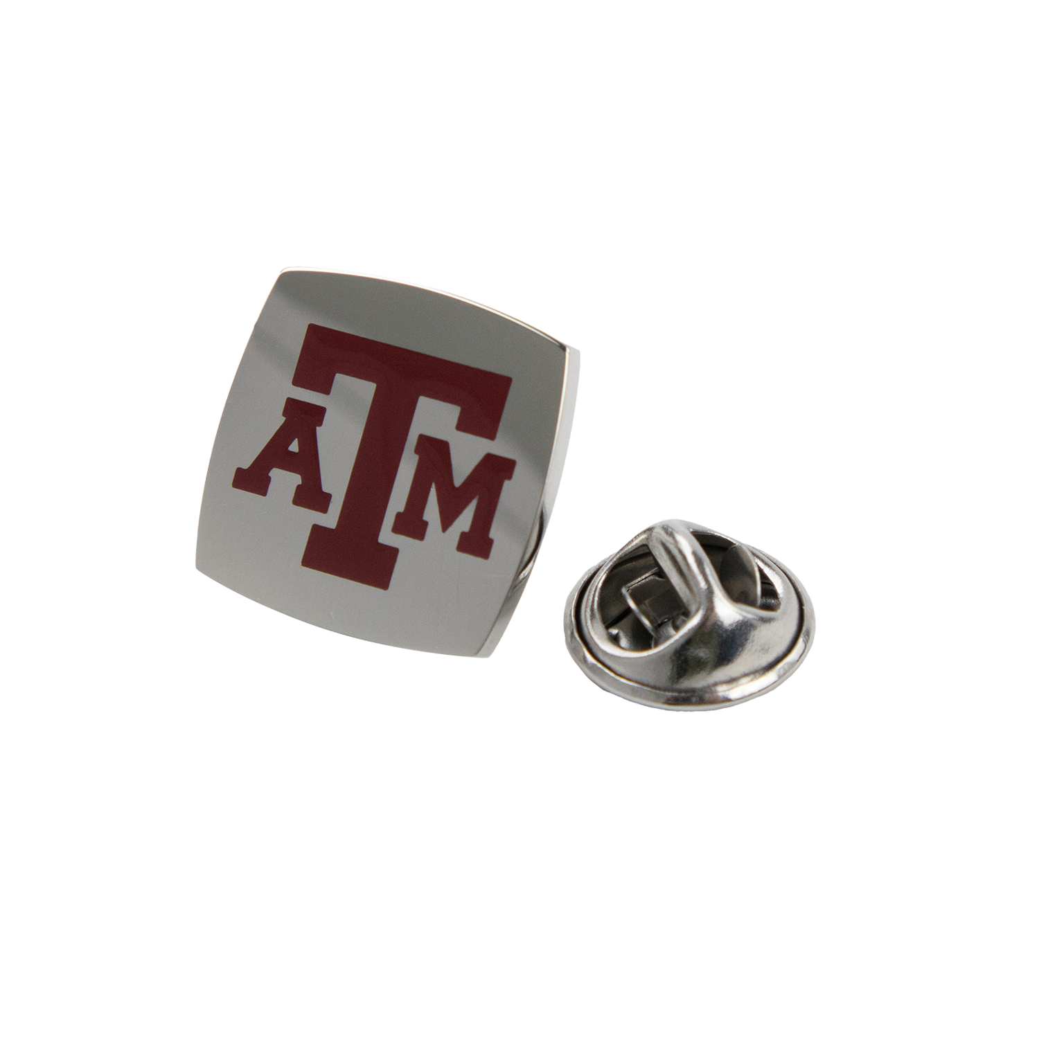 A silver square pin. A&M is written in maroon block letters on the front. 