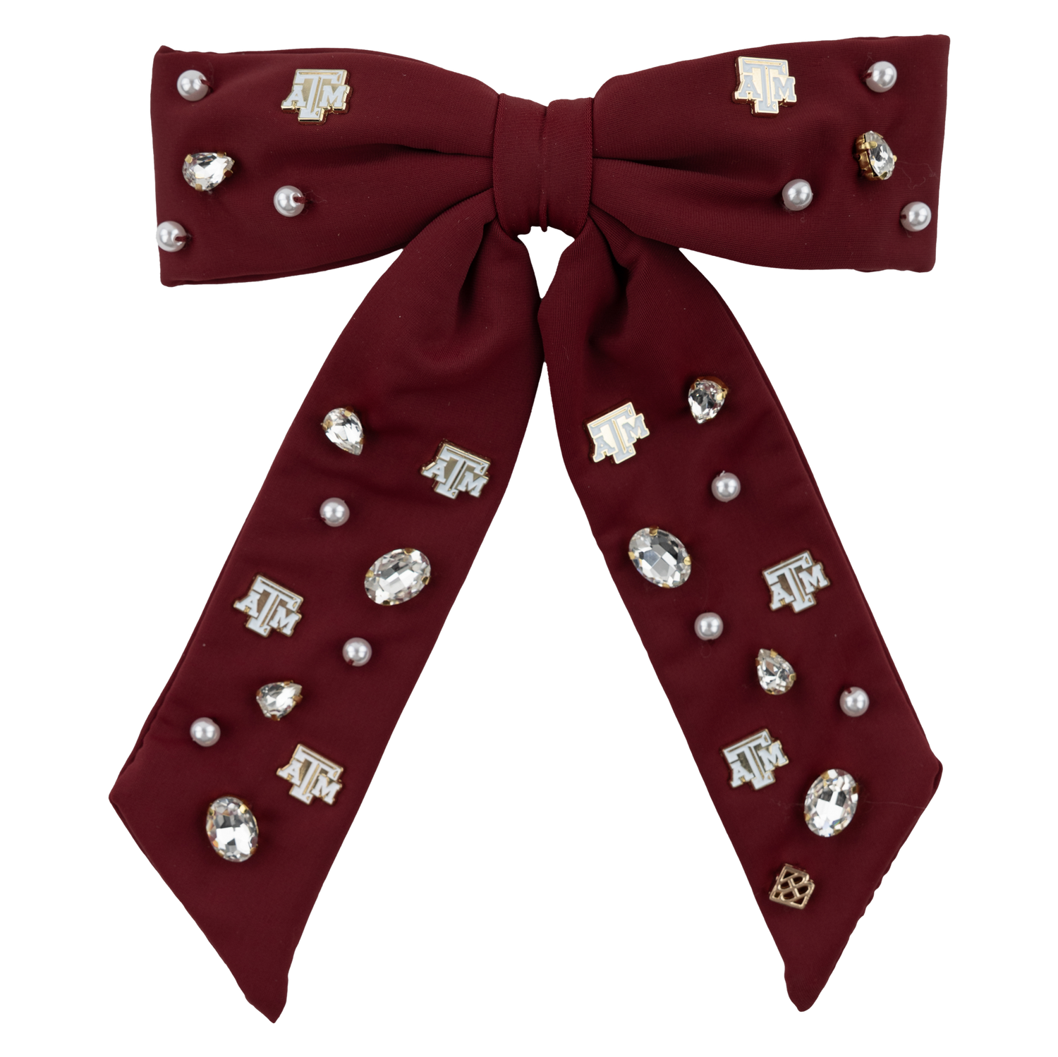 A maroon bow hair clip with pearls, gems, and A&M charms scattered throughout 